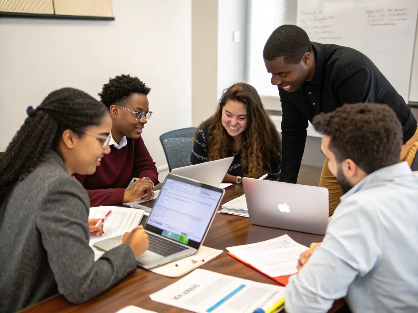 A diverse group of MBA students collaborating on a project in a modern, sunlit study room, showcasing teamwork and engagement.
